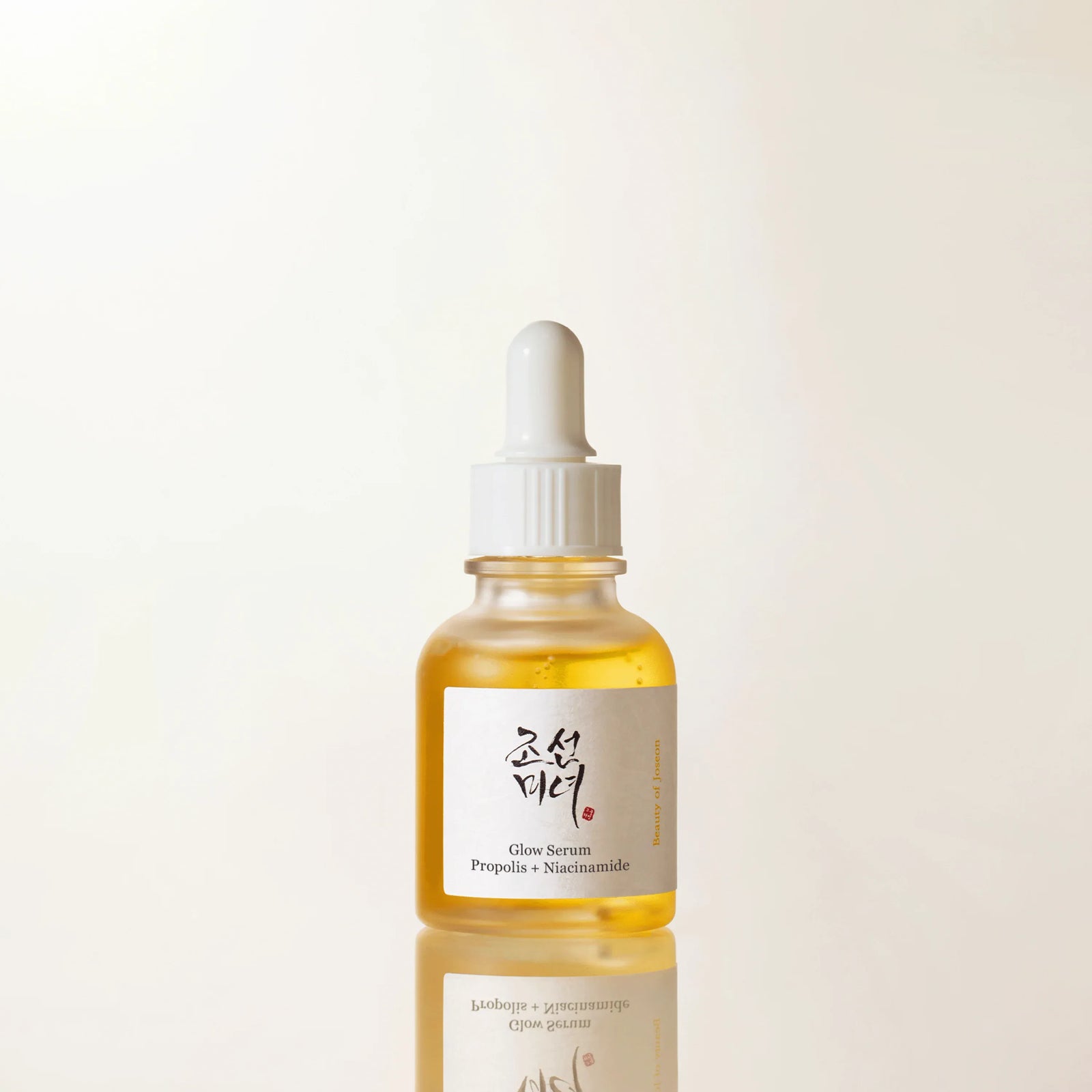 Beauty of Joseon Glow Serum, propolis and niacinamide, 30 ml amber glass bottle with a dropper cap, front label facing camera against a white background.