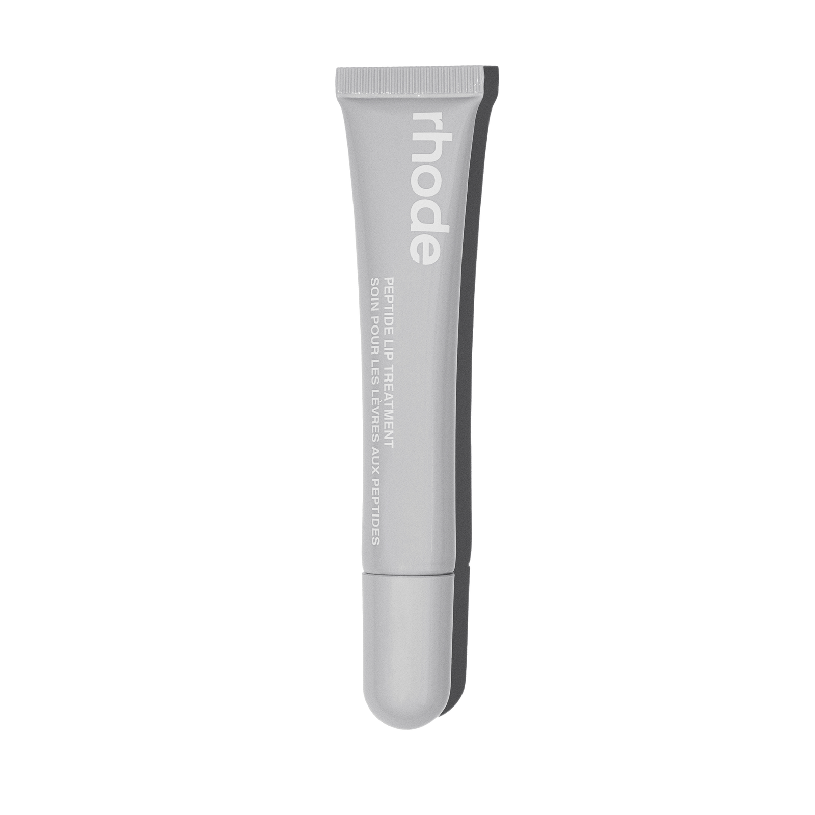The grey rhode Peptide Lip Treatment squeeze tube, unscented variant, labelled in English and French, against a plain background